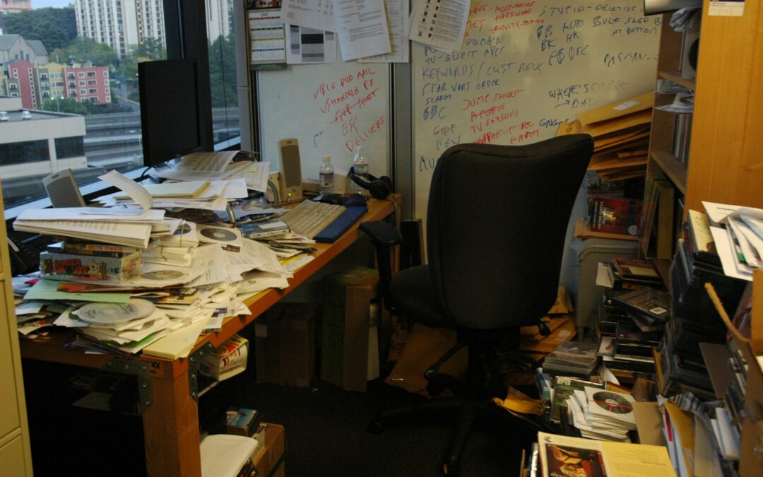 Office with messy desk and clutter.